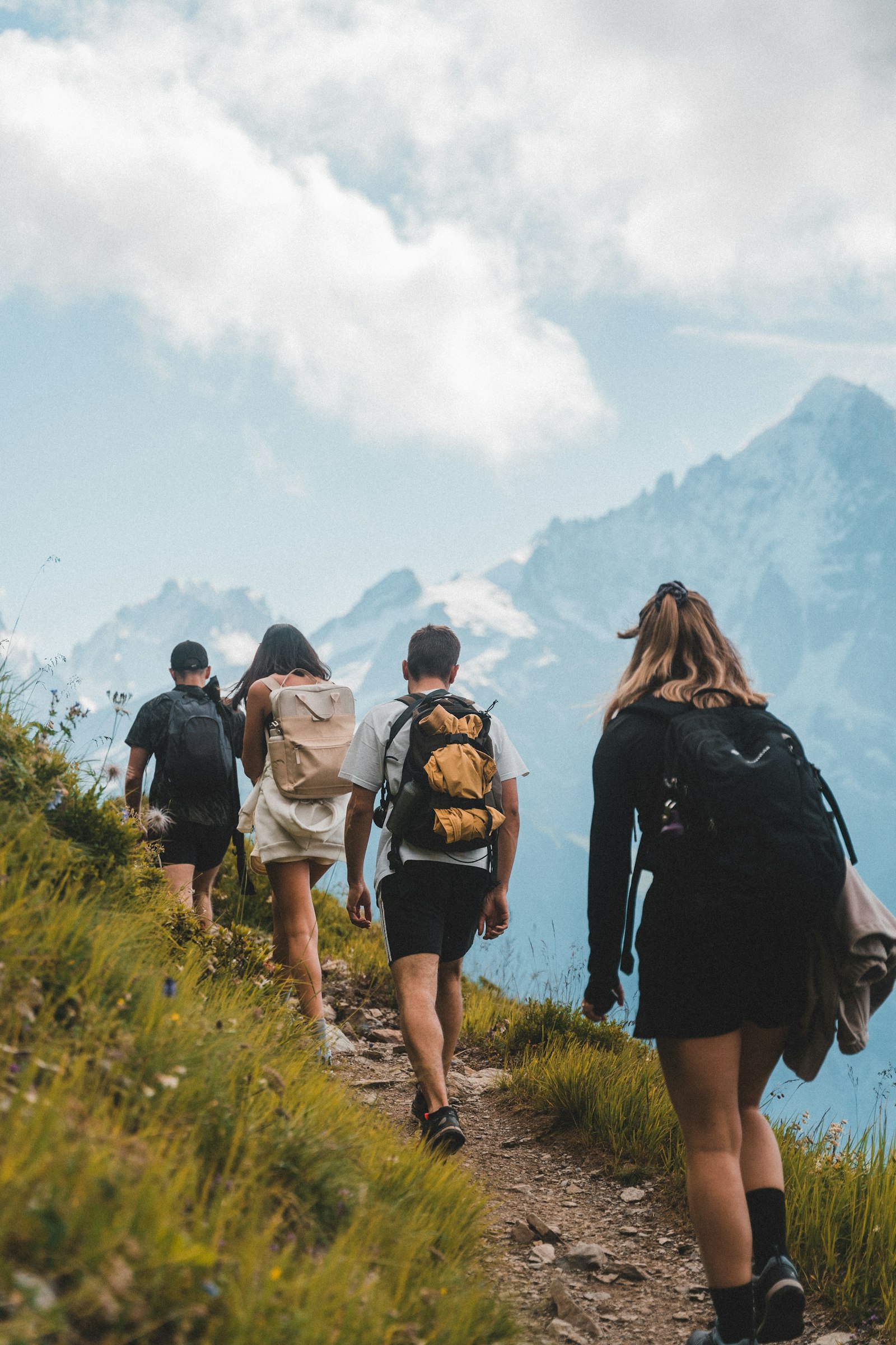 Friends hiking a grassy mountain trail