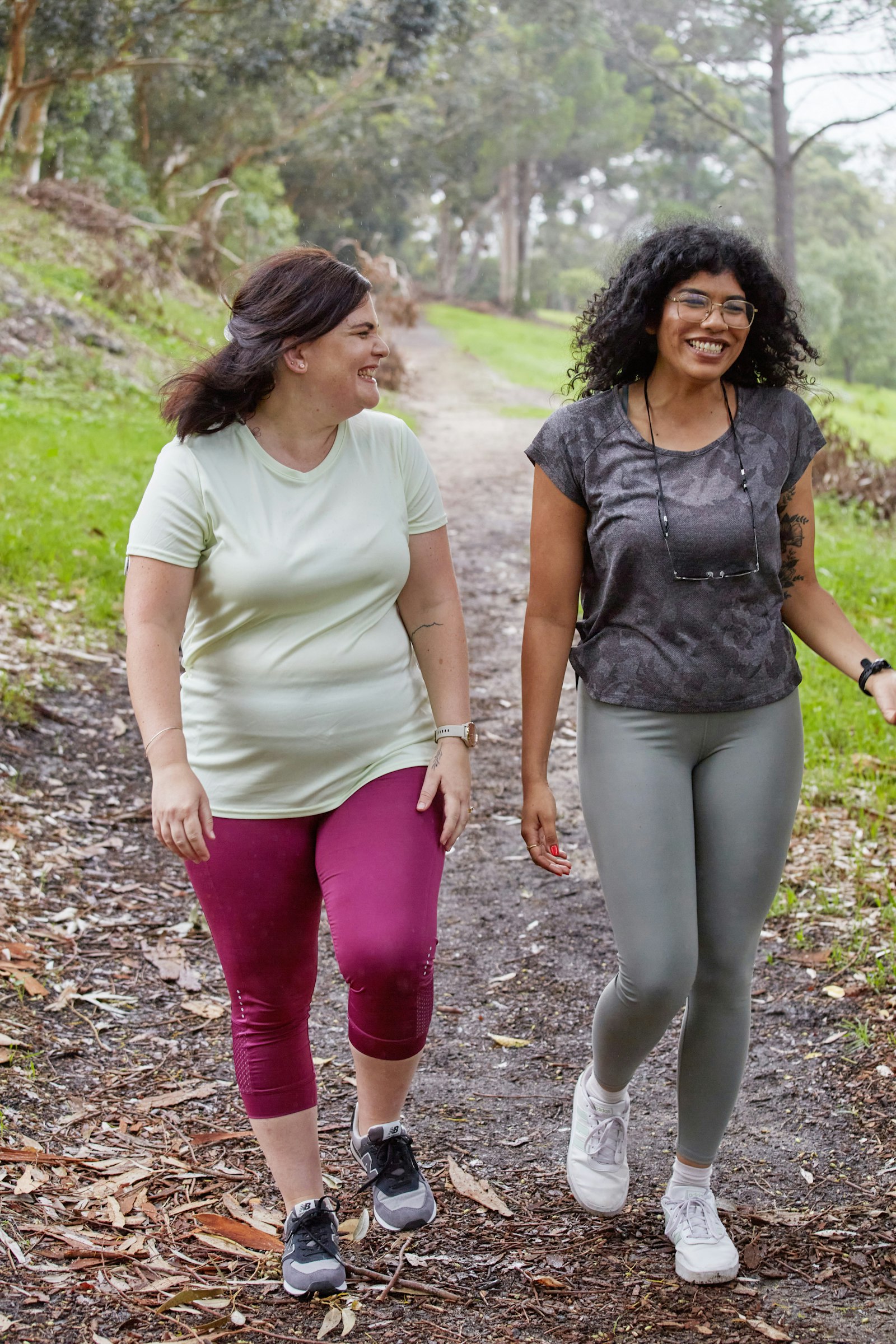 Two women walking together on a wooded trail