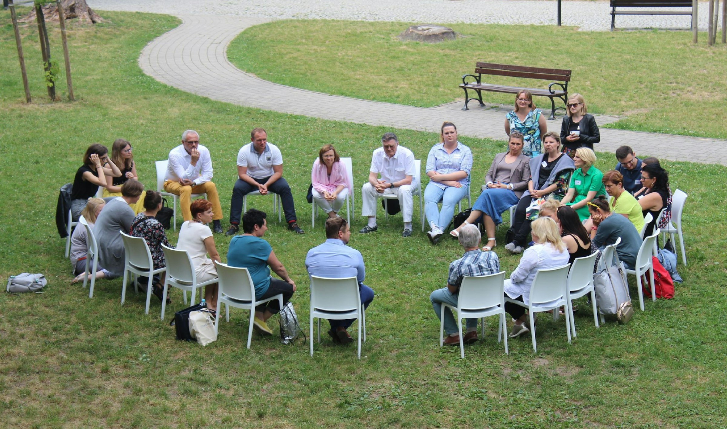 Group sitting in a circle on a park lawn